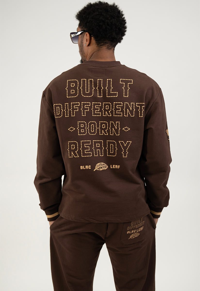 Person wearing a brown sweatshirt with text on the back against a white background