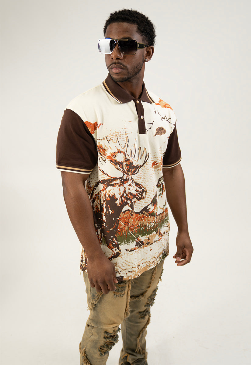 Man wearing a cream polo shirt with moose, nature-themed design on a white background