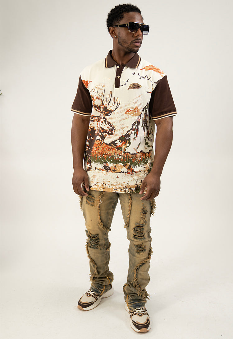 Man wearing a graphic polo shirt and distressed jeans on a white background