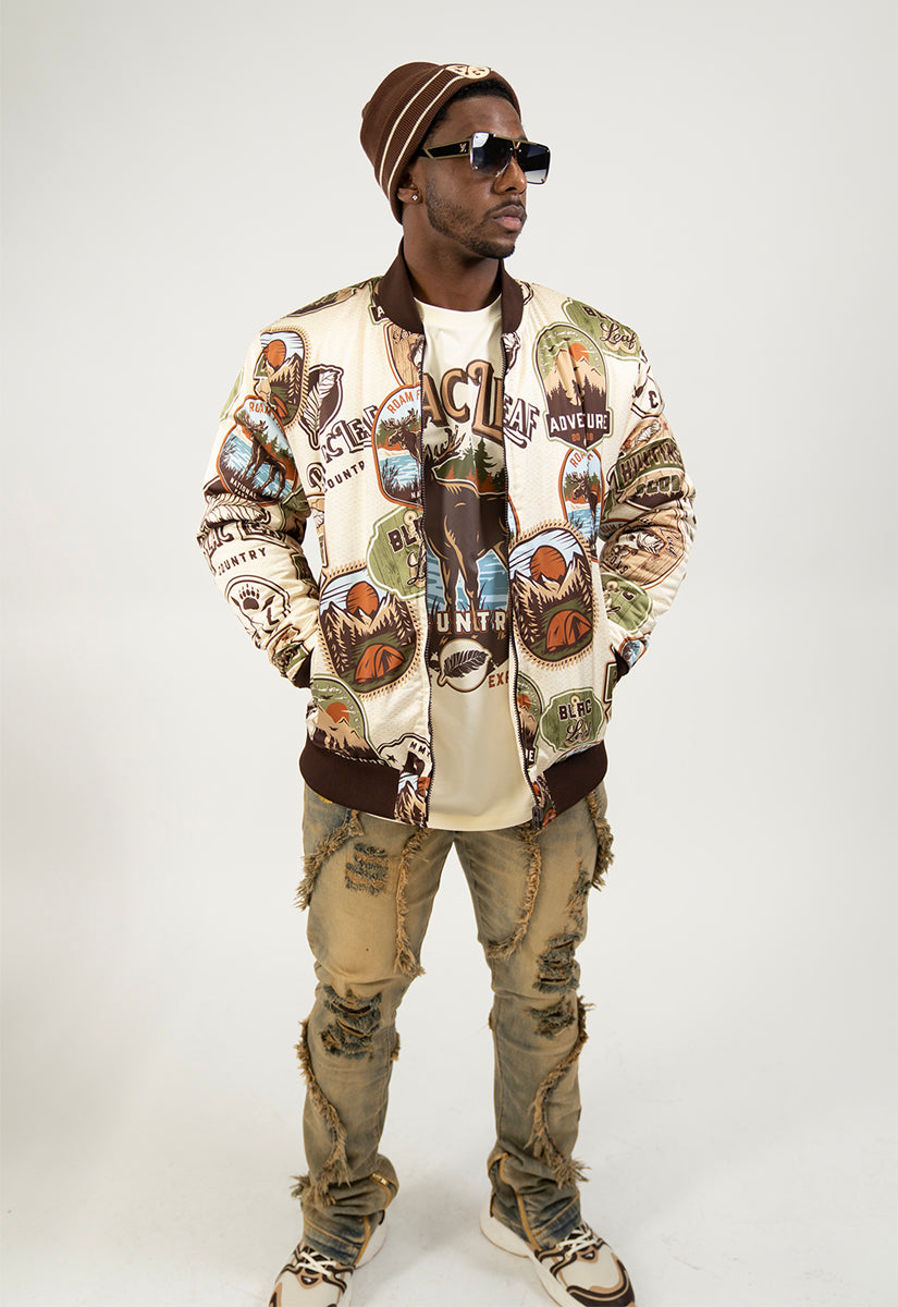 Person wearing a stylish outfit with a Reversible bomber jacket, beanie, and graphic t-shirt on a white background.
One side of jacket is nature logos.