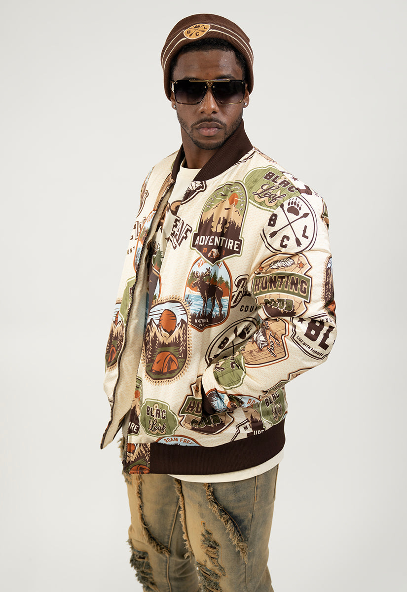 Man wearing a Blac Leaf Country Varsity jacket with various patches printed on jacket and a Brown Beanie.