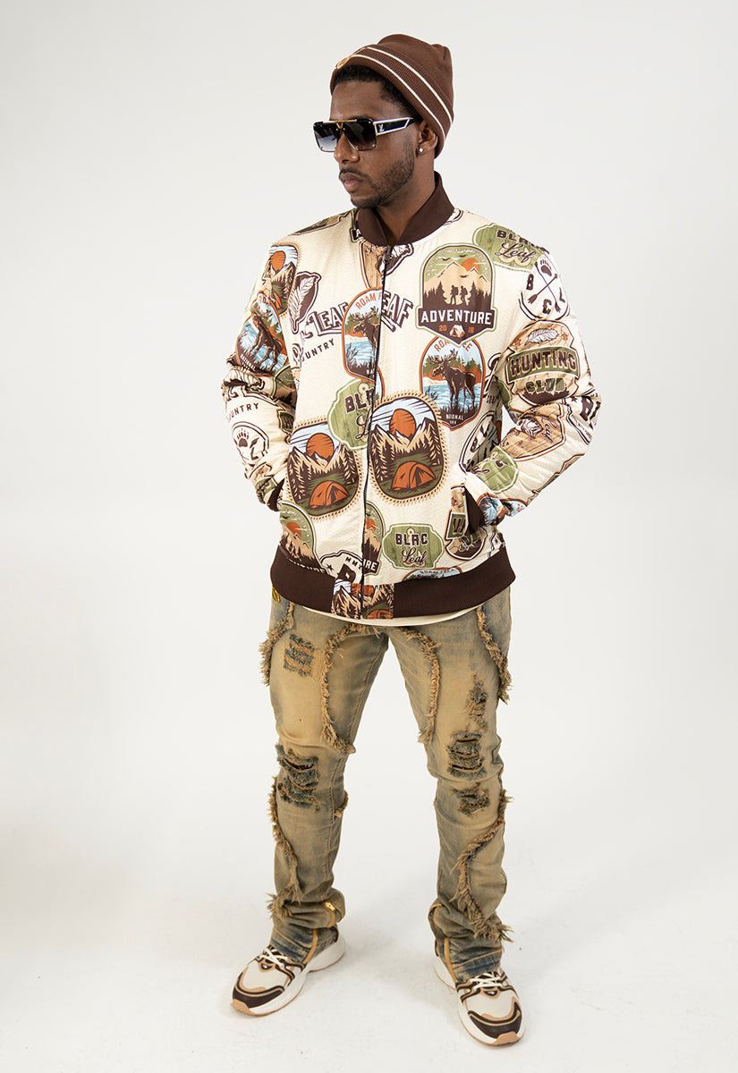 Person wearing a bomber jacket with graphic nature designs on a white background
